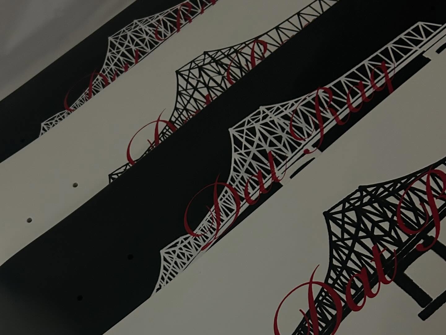 Close-up of a Dat Raq deck showing bridge truss line-work and red script